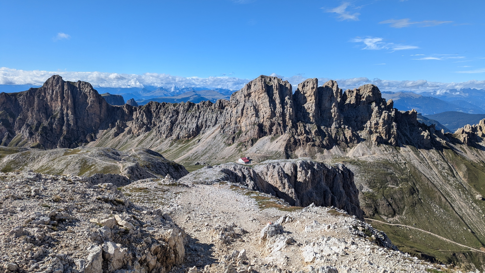 Views over Rifugio Alpe di Tires with its famous red roof, located under the impressive cliffs in the Rosengarten group in the Dolomites