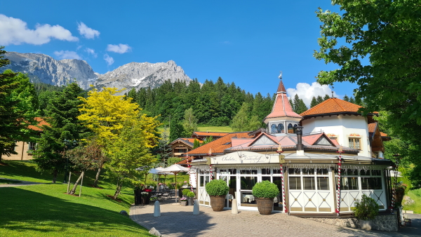 Leitenhof Hotel in Scheffau. The hotel reception is surrounded by trees with mountains behind
